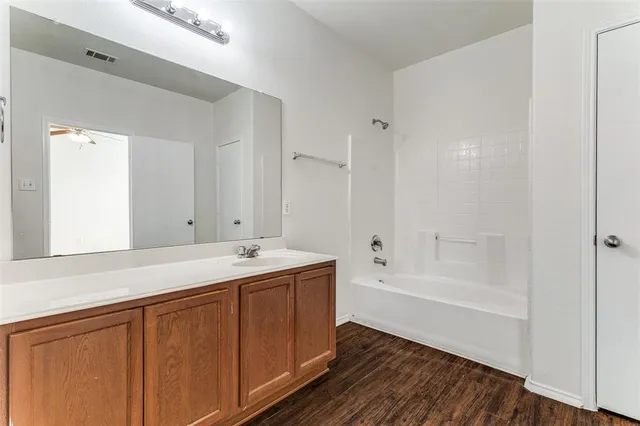 a bathroom with a tub sink and mirror