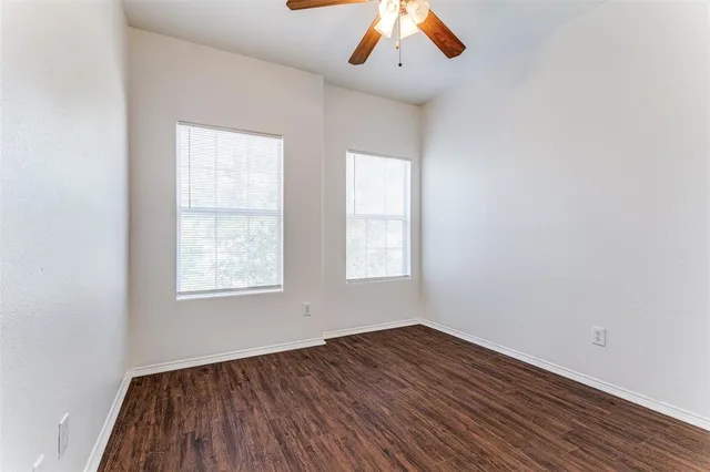an empty room with wooden floor and window