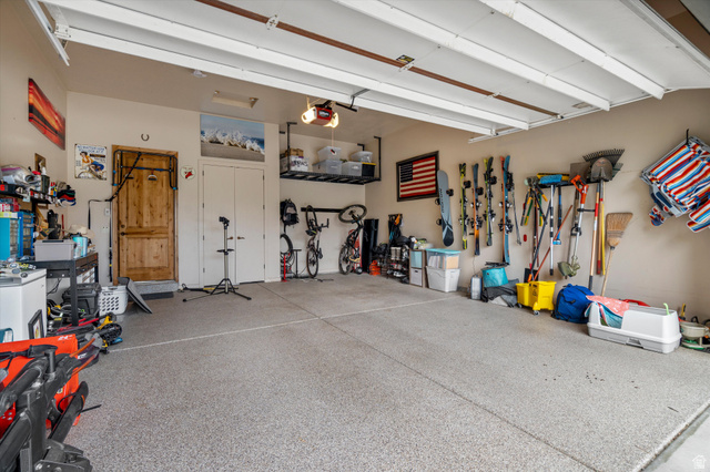 4892 Eagle Rdg Drive Eden, UT 84310 - Photo 24 of 39 Spacious garage with an epoxy-coated floor, overhead storage racking, and a wooden entry door