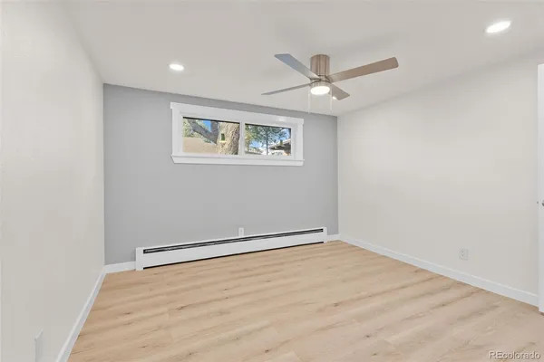 an empty room with a ceiling fan and wooden floor