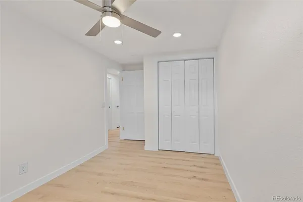 an empty room with a ceiling fan and a window