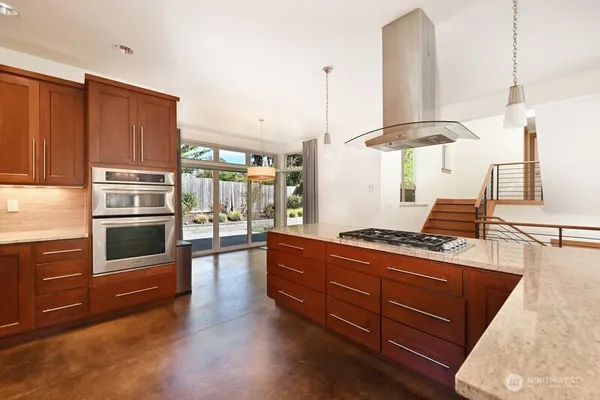a kitchen with stainless steel appliances granite countertop a stove a sink and a refrigerator