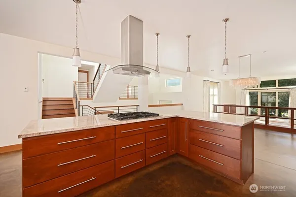 a kitchen with stainless steel appliances granite countertop a sink a stove and a wooden floor