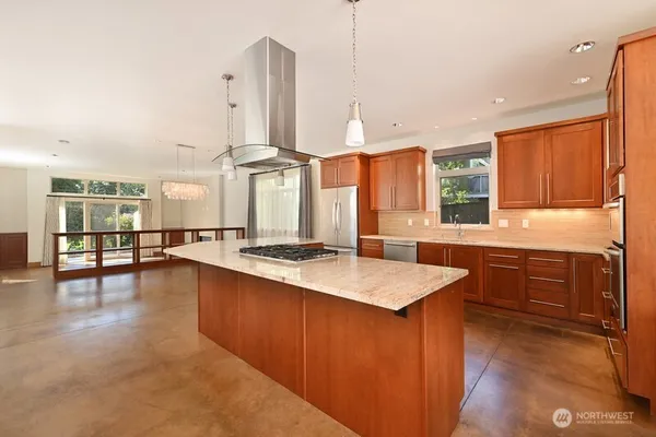 a kitchen with stainless steel appliances granite countertop a sink a stove and a wooden floors