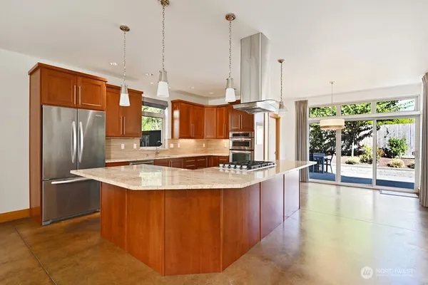 a kitchen with stainless steel appliances granite countertop a sink a refrigerator and a stove