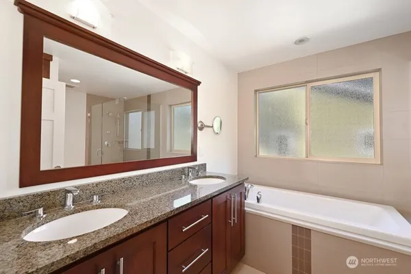 a bathroom with a granite countertop sink and a mirror