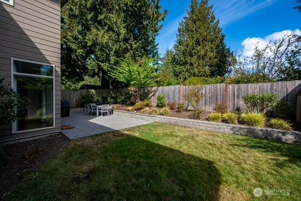 a view of patio with table and chairs and potted plants with wooden fence