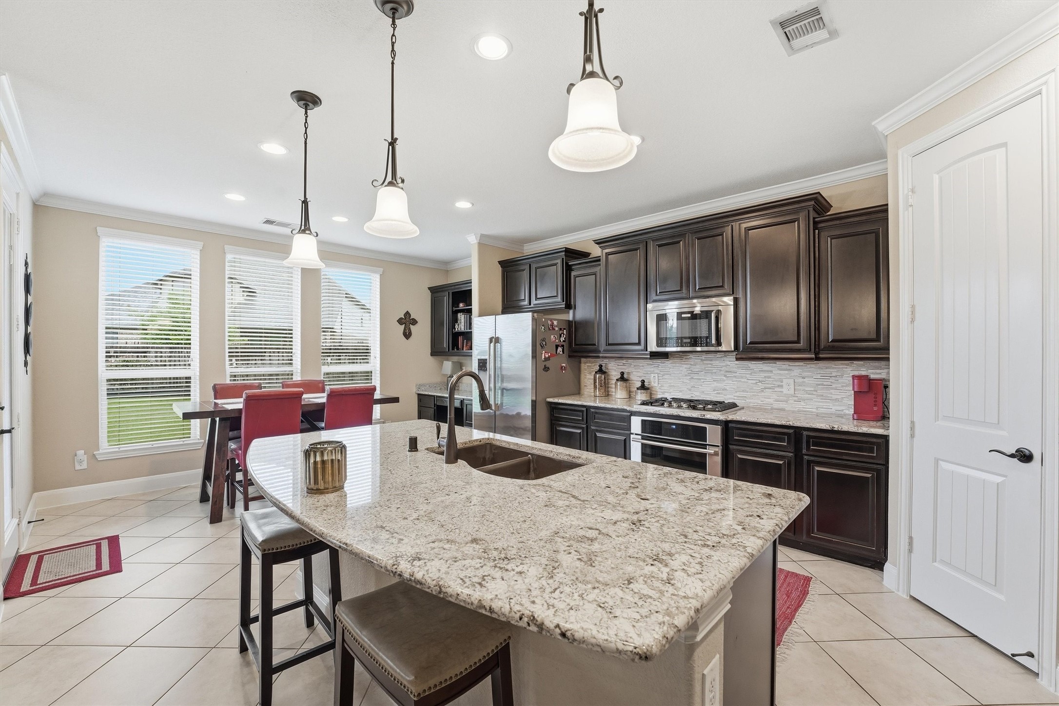 12506 Northpointe Ridge Lane Tomball, TX 77377 - Photo 7 of 31 a kitchen with stainless steel appliances granite countertop a kitchen island a stove a table and chairs in it
