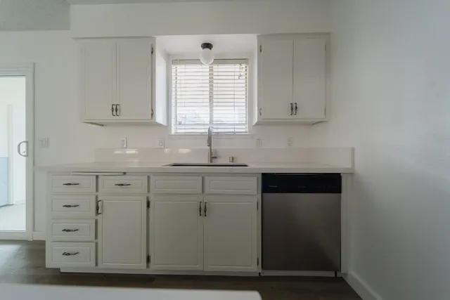 a kitchen with cabinets appliances and a window