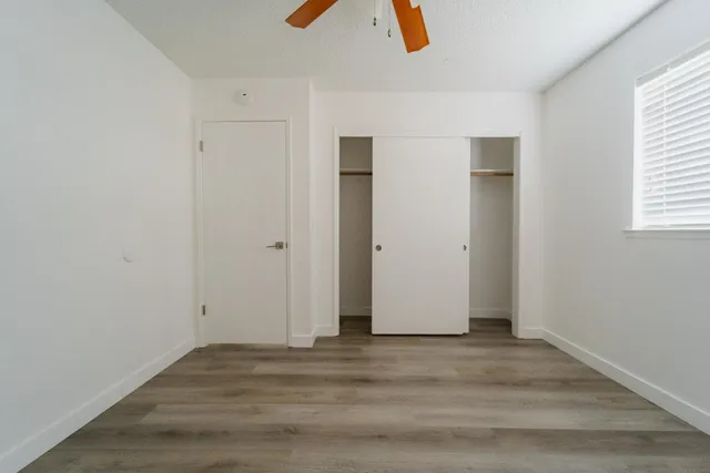 an empty room with closet and windows