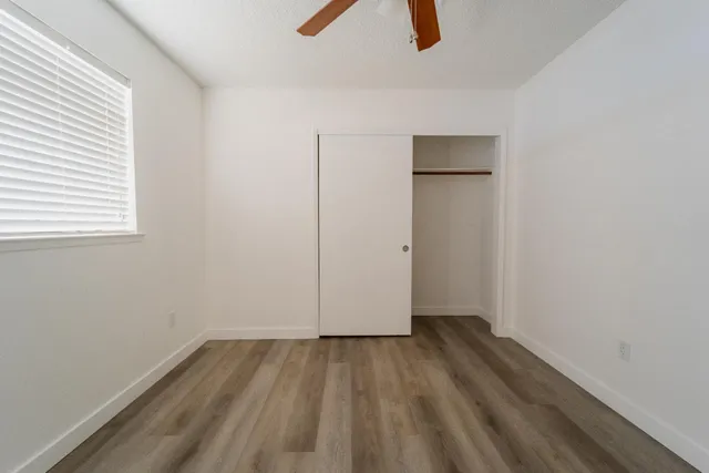 an empty room with closet and windows