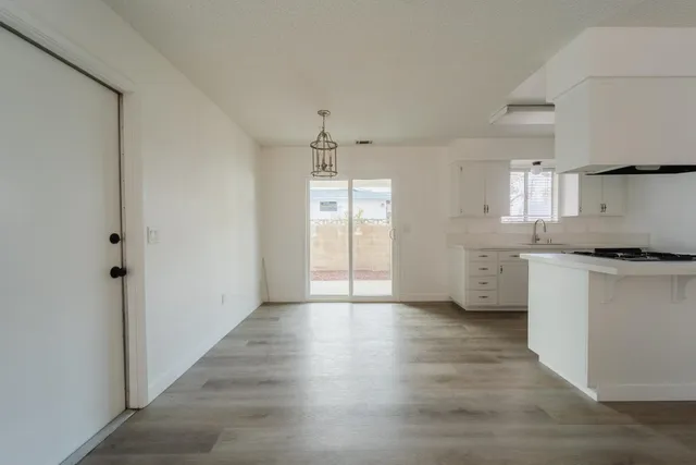 a view of a kitchen with a sink and dishwasher with wooden floor
