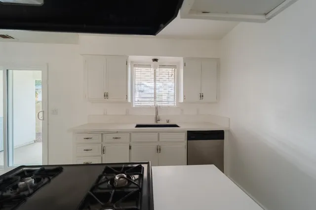 a kitchen with a sink a stove and cabinets