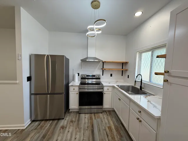 a kitchen with a refrigerator cabinets and wooden floor