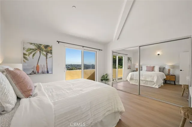 a bedroom with a large bed and wooden floor