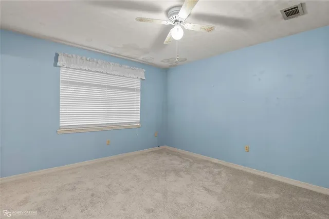 a view of a room with a ceiling fan and a window