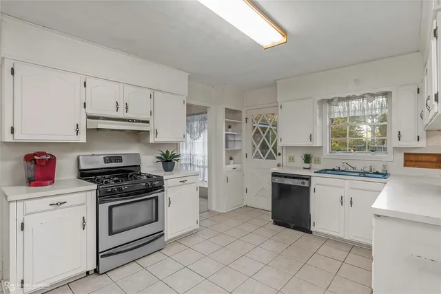 a kitchen with cabinets appliances and a window
