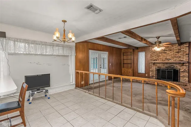 a view of a livingroom with furniture a fireplace and chandelier