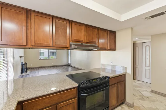 a kitchen with granite countertop a stove and cabinets
