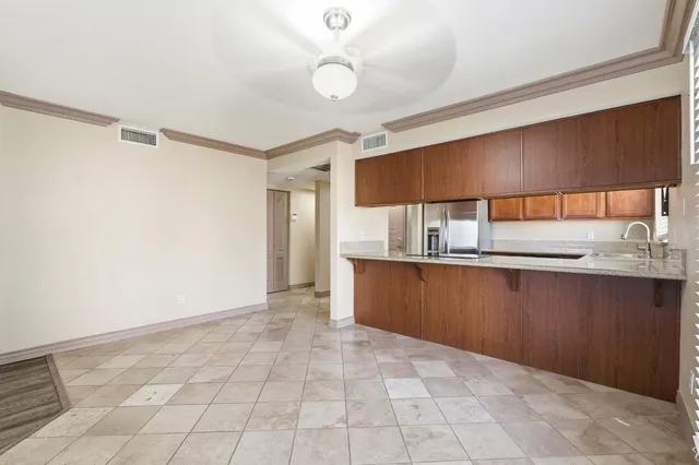 a kitchen with granite countertop a stove a sink and a refrigerator