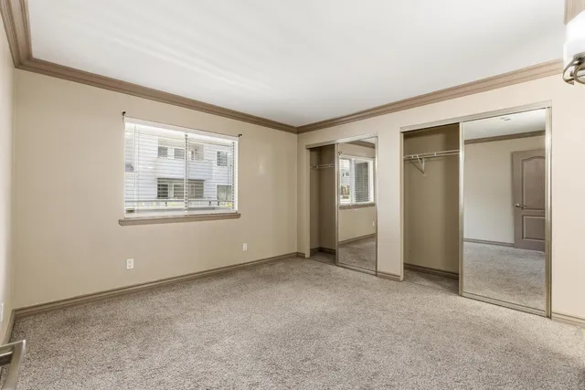 an empty room with windows and closet