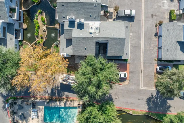 an aerial view of residential houses with outdoor space and trees