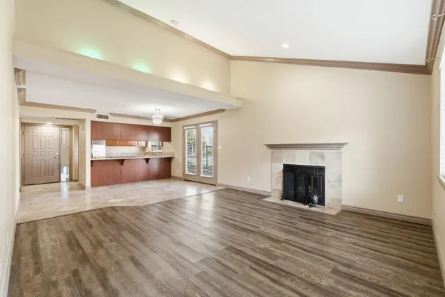 a view of empty room with wooden floor and fireplace