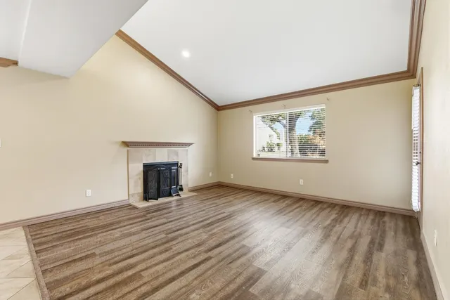 an empty room with windows and fireplace