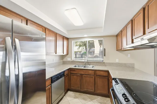 a kitchen with a sink stove top oven and cabinets