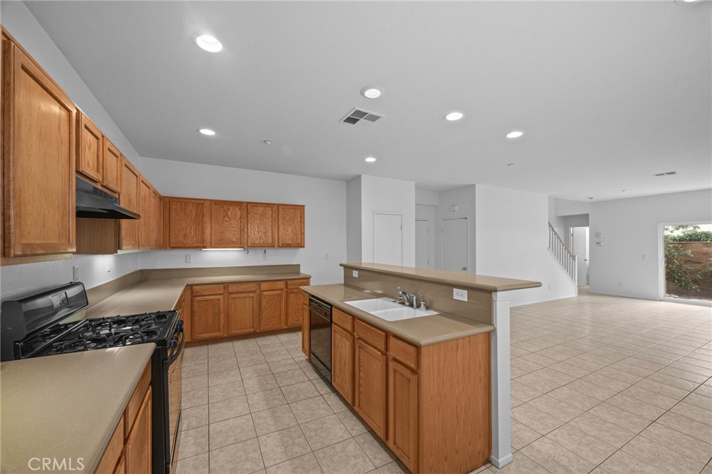 7353 Ellena West, Unit 112 Rancho Cucamonga, CA 91730 - Photo 12 of 36 a kitchen with a stove a sink a refrigerator and a counter top space
