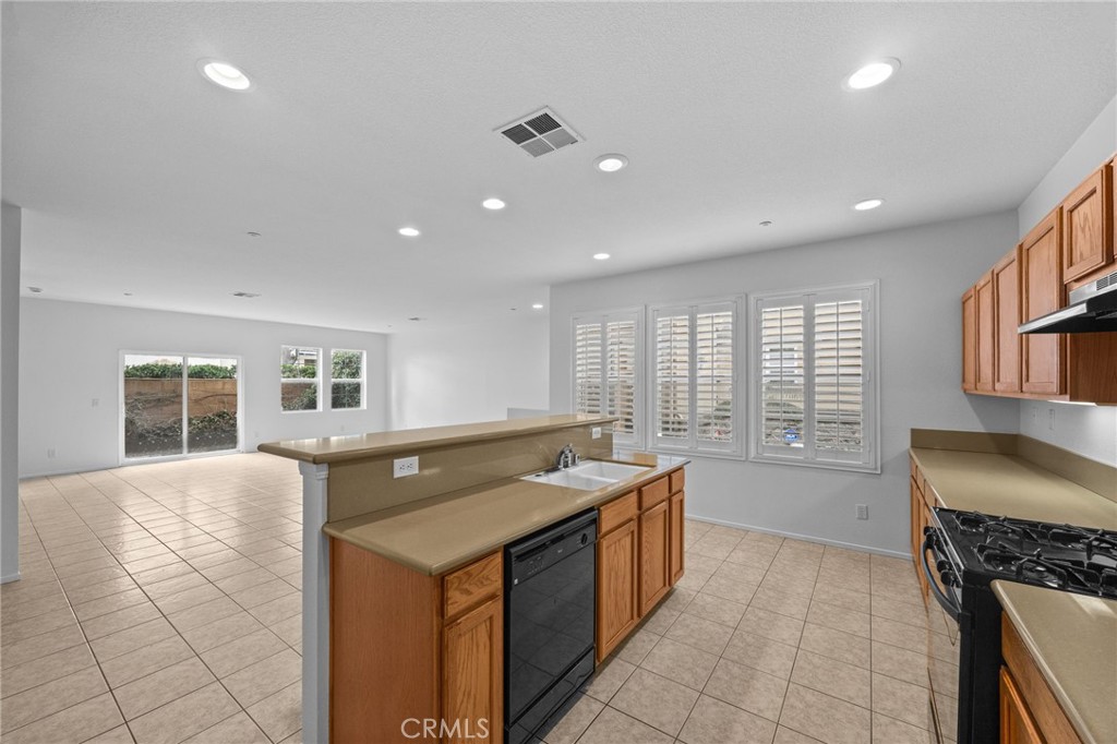 7353 Ellena West, Unit 112 Rancho Cucamonga, CA 91730 - Photo 13 of 36 a kitchen with a stove sink and cabinets