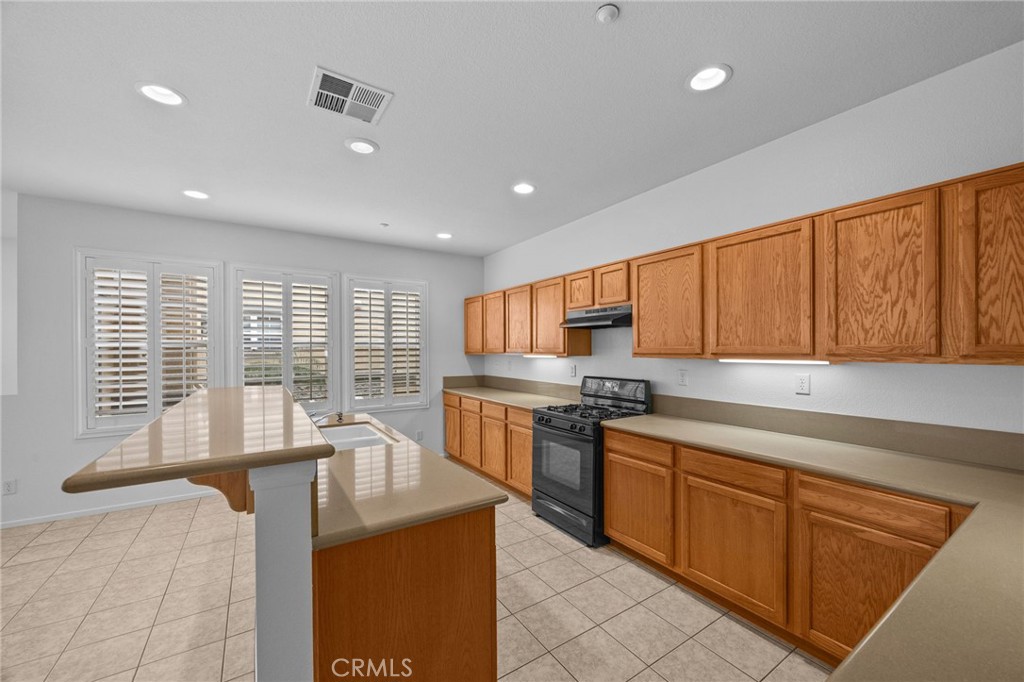 7353 Ellena West, Unit 112 Rancho Cucamonga, CA 91730 - Photo 14 of 36 a kitchen with stainless steel appliances granite countertop a stove a sink and a refrigerator