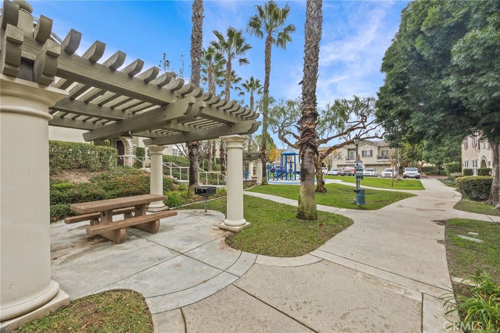 7353 Ellena West, Unit 112 Rancho Cucamonga, CA 91730 - Photo 31 of 36 a view of a patio with table and chairs potted plants and large tree