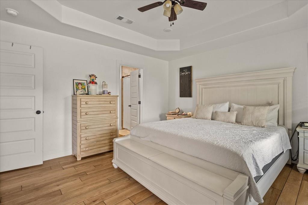408 South Cedar Street Leonard, TX 75452 - Photo 13 of 22 a spacious bedroom with a bed and a chandelier