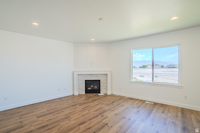 45 North Scarlet Maple Road, Unit 4317 Vineyard, UT 84059 - Photo 13 of 35 Living area featuring wood-finish flooring, a white mantel, and a fireplace with a light-tiled surround