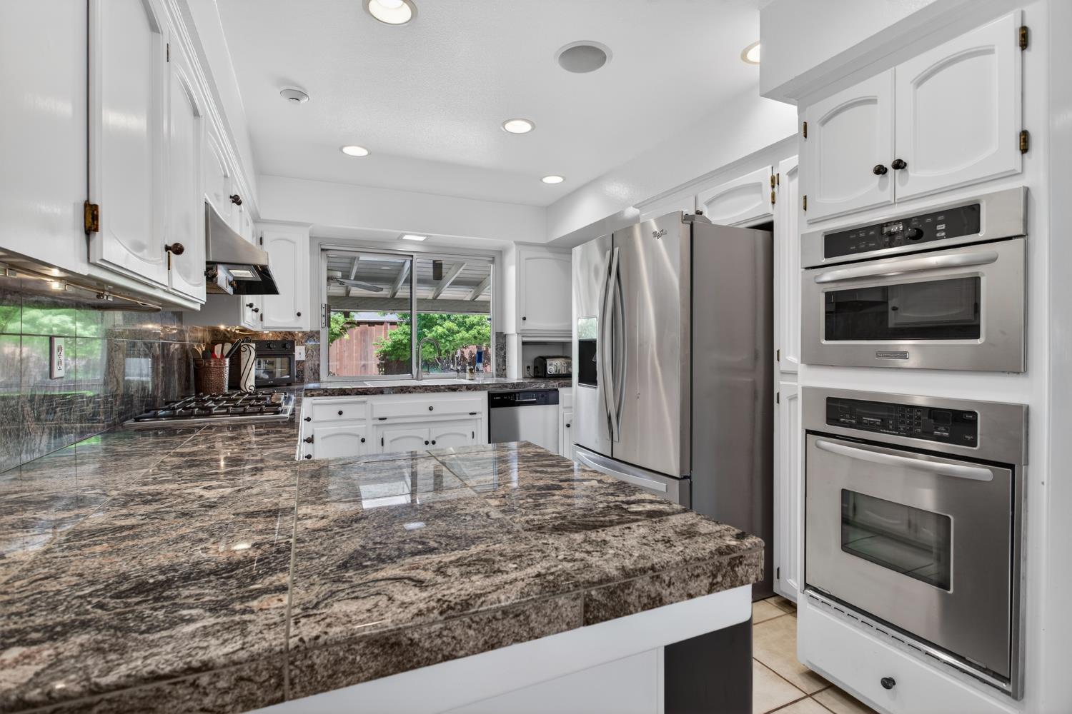 1909 Chelwood Way Modesto, CA 95355 - Photo 19 of 44 a kitchen with stainless steel appliances kitchen island granite countertop a stove refrigerator and microwave