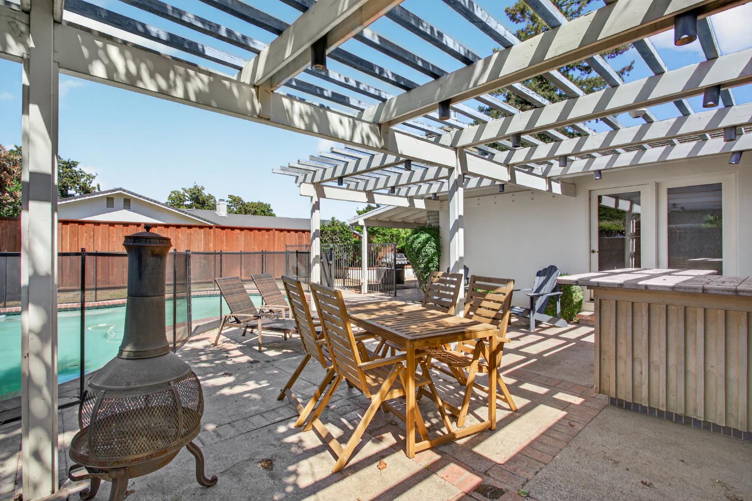 1909 Chelwood Way Modesto, CA 95355 - Photo 36 of 44 a view of a patio with table and chairs potted plants with wooden floor and fence