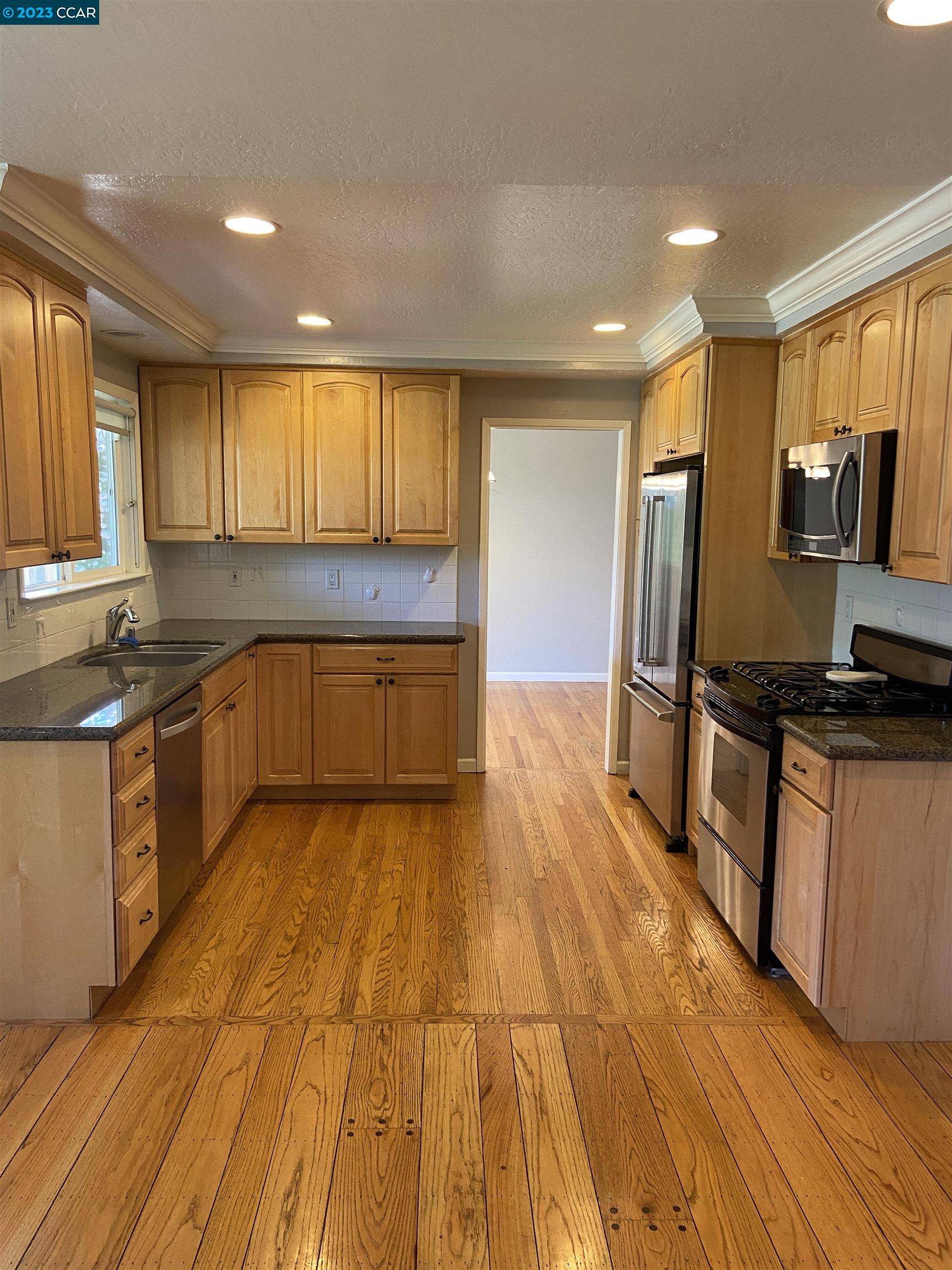 2202 Cascade Drive Walnut Creek, CA 94598 - Photo 6 of 23 a large kitchen with kitchen island granite countertop a sink and stainless steel appliances