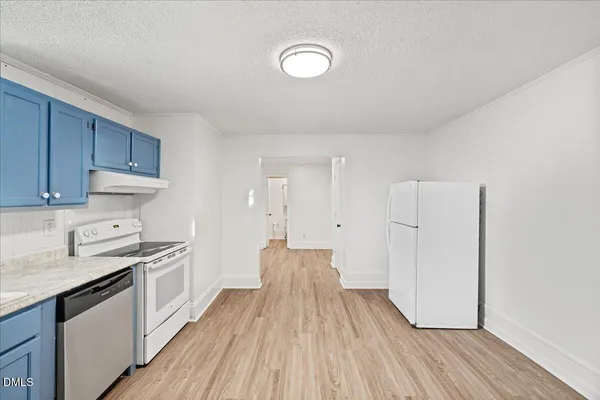 a kitchen with wooden cabinets and white appliances