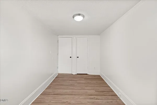 a view of an empty room with wooden floor