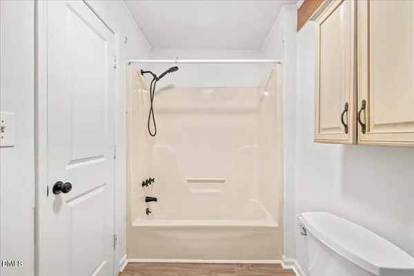 a bathroom with a shower a toilet and a window