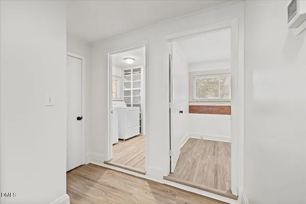 view of room with window and hallway