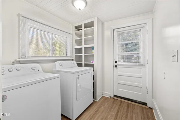 a view of washer and dryer with bathroom in the background