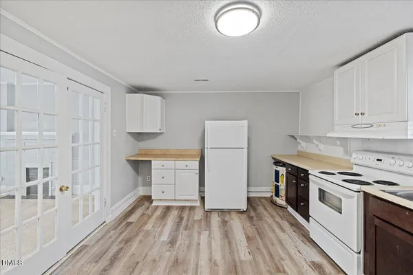 a kitchen with cabinets appliances and a wooden floor