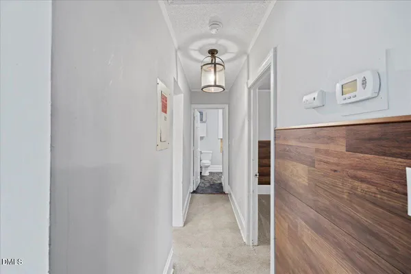 a view of a hallway with wooden floor and staircase