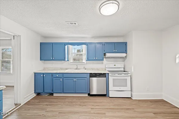 a kitchen with a sink and wooden floor