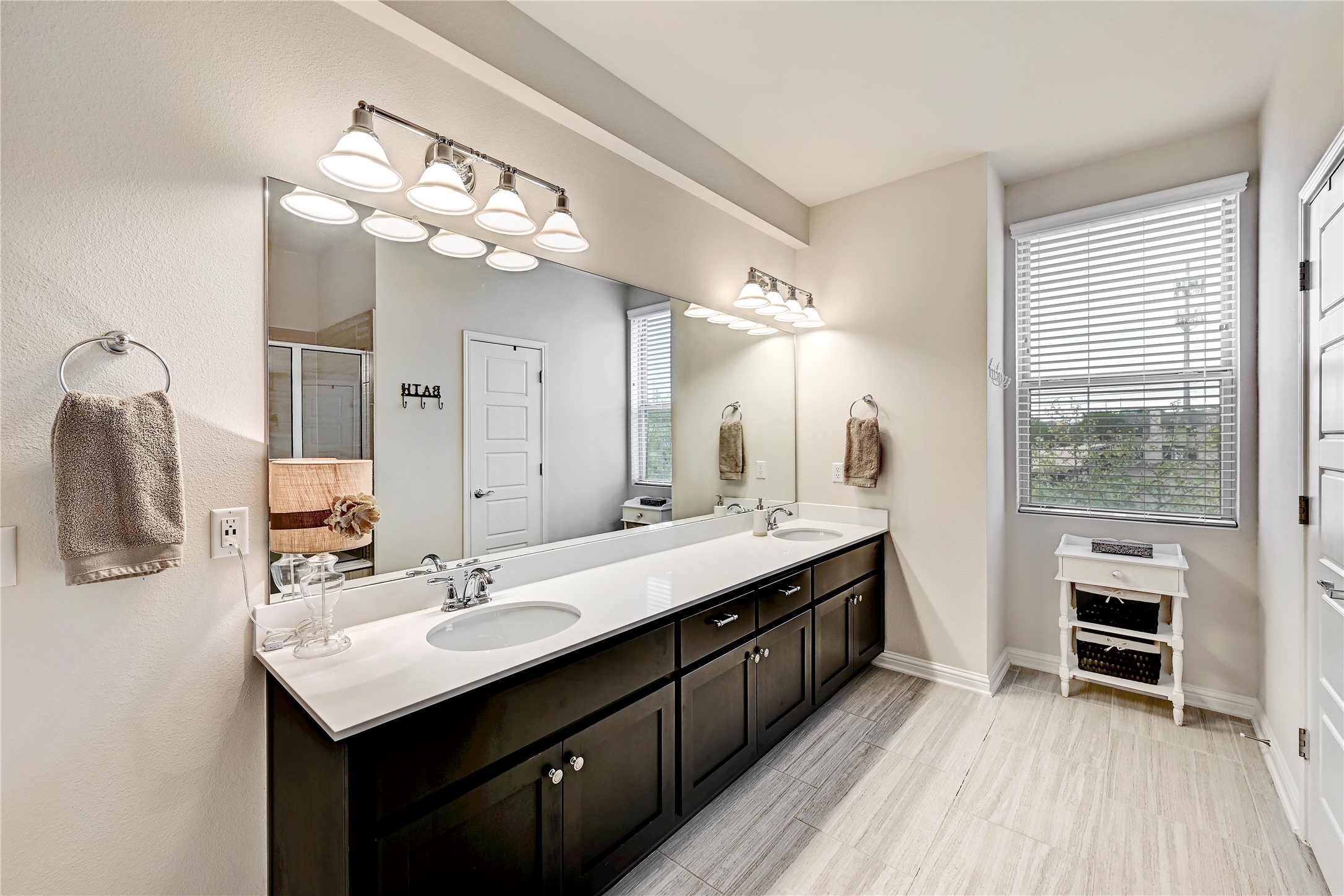 6814 East Riverside Drive, Unit 64 Austin, TX 78741 - Photo 11 of 17 Double vanities with sleek countertops and ample storage enhance this well-appointed primary bathroom.