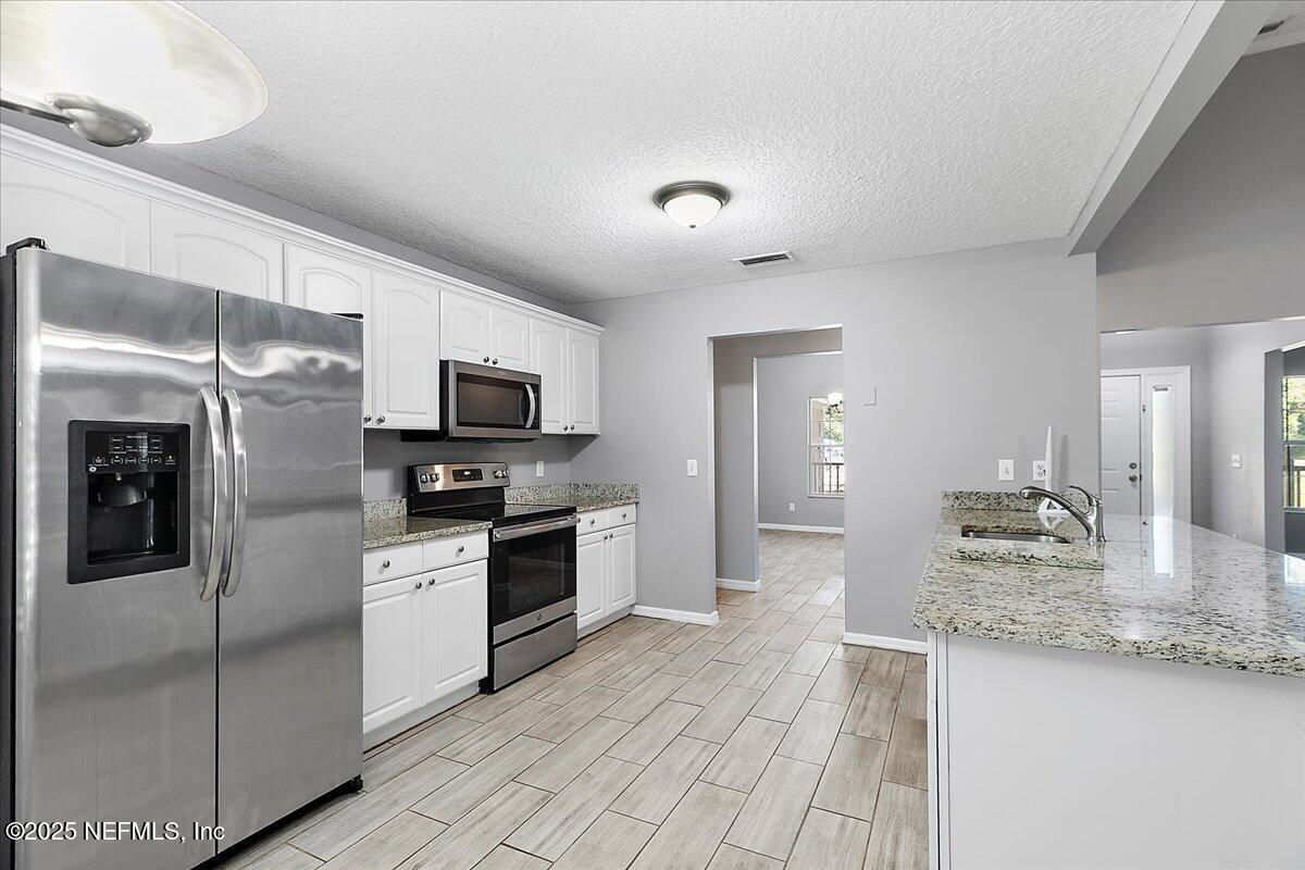 1315 Fruit Cove Road South Jacksonville, FL 32259 - Photo 8 of 19 a large kitchen with granite countertop a large counter top stainless steel appliances and cabinets