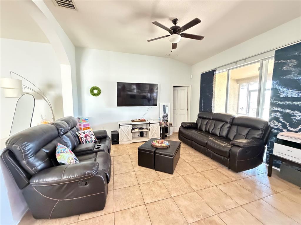 945 Tramells Trail Kissimmee, FL 34744 - Photo 11 of 36 a living room with furniture and a flat screen tv