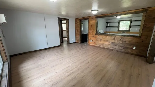 a view of an empty room and a bathroom with mirror